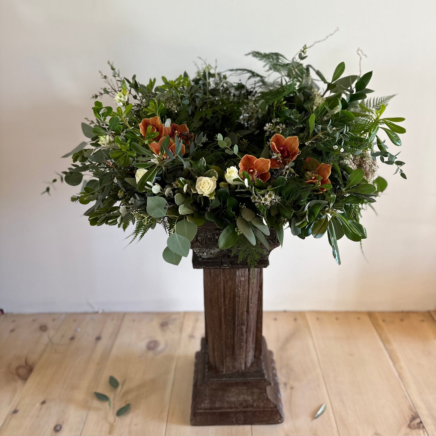 Mostly greens urn spray with orchids and white roses