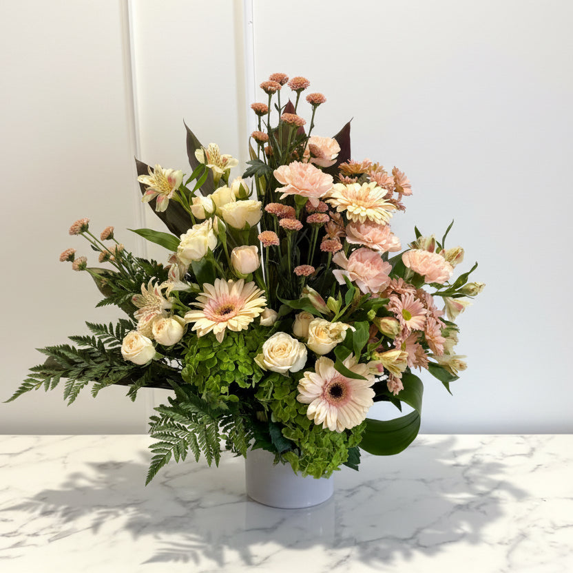 Bouquet of flowers in a white vase on a marble surface with a light gray background
