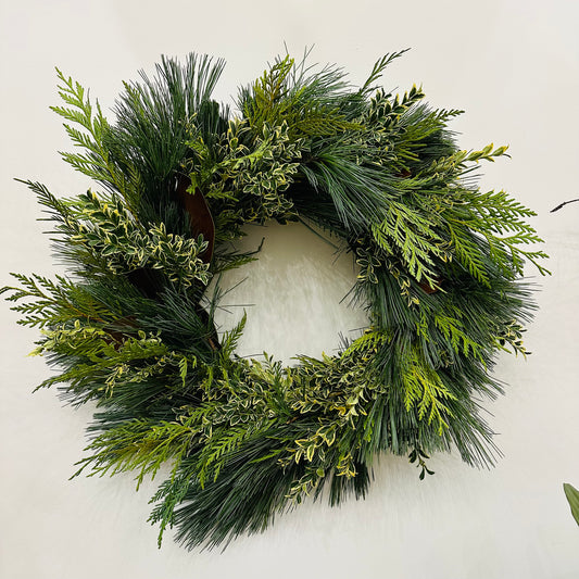 A  16" fresh greens wreath with a variety of green leaves arranged in a circular form.